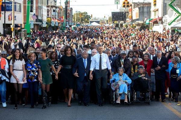 President Barack Obama and First Lady Michelle Obama join hands with Rep. John Lewis, D-Ga. as they lead the walk across the Edmund Pettus Bridge to commemorate the 50th Anniversary of Bloody Sunday and the Selma to Montgomery civil rights marches
