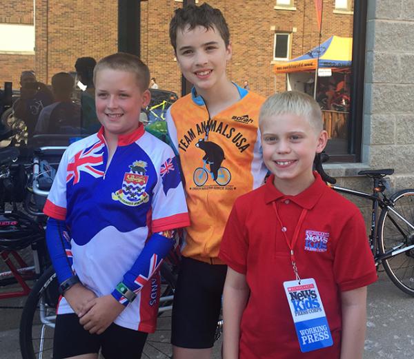 Alex Henry (on left) (10 years old from the Cayman Islands), Henry Kaeser (in the middle) (13 years old from Washington state) pose with Brandon after discussing why they like participating in RAGBRAI.