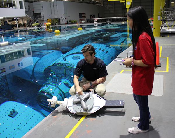 Astronaut trainer John Narramore shows Bridget around the Neutral Buoyancy Laboratory.