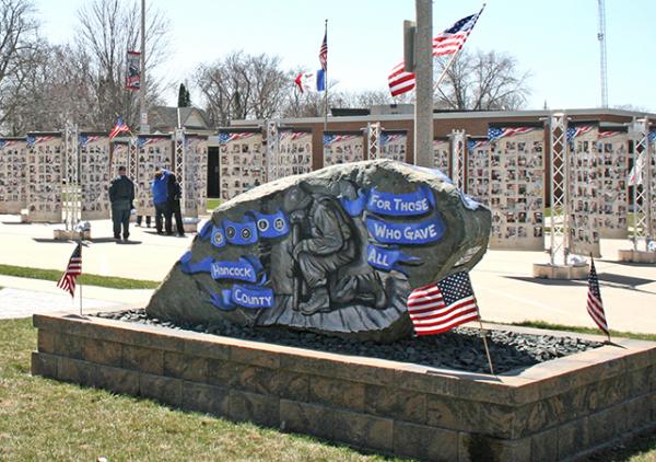 Photo of the memorial towers with Hancock County's Freedom Rock in front.