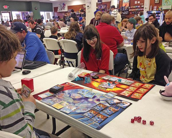 Esther observes a game of Pokemon being played.