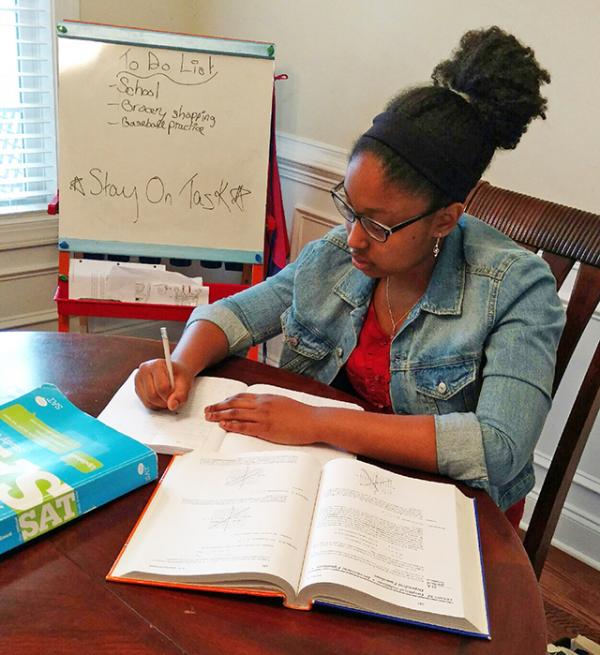 Kayla studies at her dining room table.