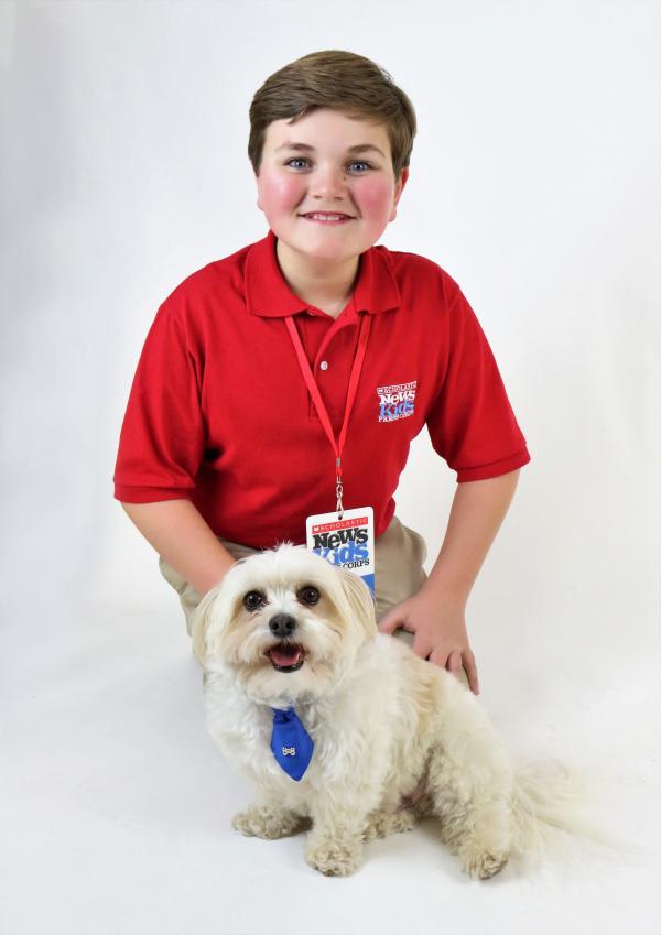 Nolan poses with Snowball during the dog’s break from a photo shoot. Nolan poses with Snowball during the dog’s break from a photo shoot.