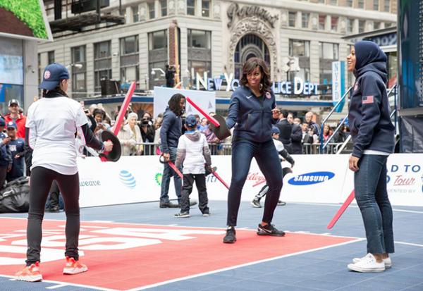 First Lady Michelle Obama participates in a fencing demonstration with Ibtihaj Muhammad of the U.S. Olympic Fencing Team during the 2016 Olympics 100 Days Out event in Times Square, New York, N.Y., April 27, 2016.