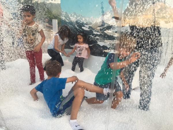 Logan and Jude Bialski playing in fake snow outside the House of Switzerland