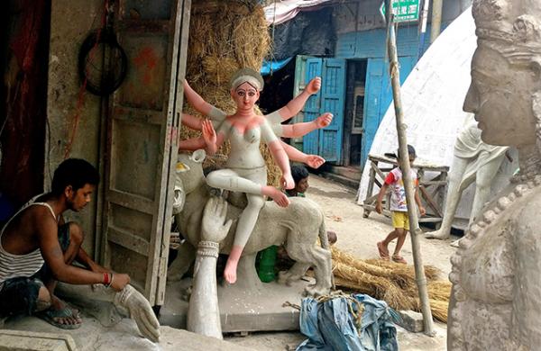 An artisan sculpts the hand of an effigy in the labyrinthine streets of Kumartuli
