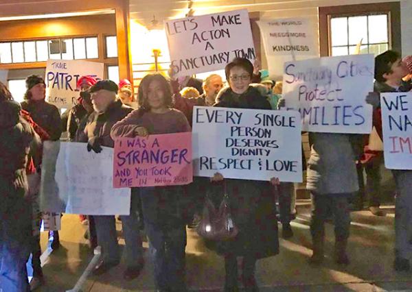 Local residents express support for making Acton, Massachusetts, a sanctuary city after President Trump instituted a temporary ban on people entering the United States from several predominately Muslim countries.