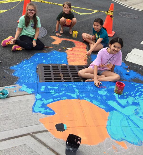 Girl Scout Troop 12881 painting a storm drain mural in Hoboken, NJ.