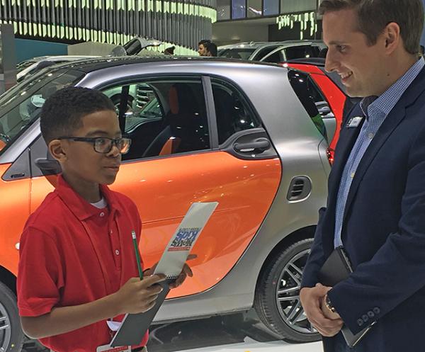 Titus learns about cars at the Detroit auto show.