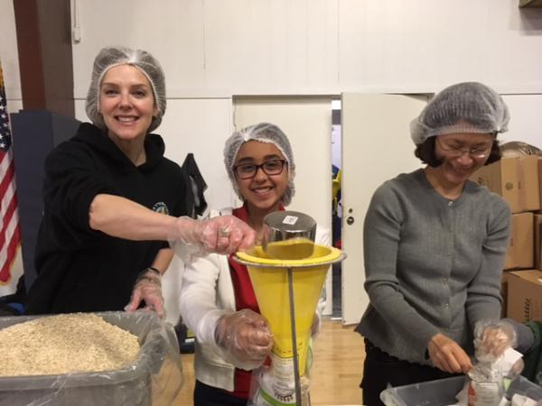 Kid reporter packing food with Samantha Koppelman and Soyoung Lee 