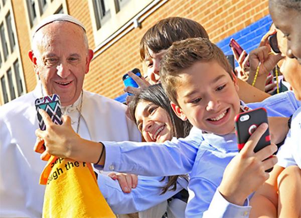 Pope Francis greets students at Our Lady Queen of Angels School in East Harlem on September 25. The Pope got a lesson in how to use smartphones.