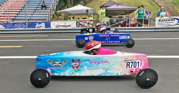 Three Soap Box Derby racers on the track at the 81st Annual All-American Soap Box Derby.