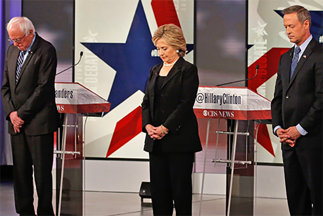 The candidates bow their heads in silence to honor the victims of the terrorist attacks in Paris, France. Left to right: Vermont Senator Bernie Sanders, former Secretary of State Hillary Clinton, and former Maryland Governor Martin O’Malley.