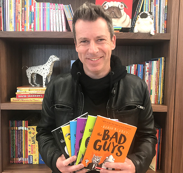 Aaron Blabey, who recently visited the United States from his home in Australia, displays books from his bestselling Bad Guys series.