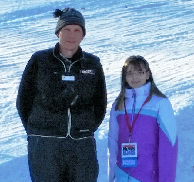 Ken Mack, Manager of Snowmaking, and Kaitlin Clark, Kid Reporter, are standing under a tower snow gun at Loon Mountain Ski Resort in Lincoln, NH.