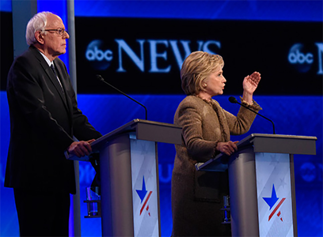 Left to right: Vermont Senator Bernie Sanders, and former Secretary of State Hillary Clinton debate the issues on December 19 in Manchester, New Hampshire.