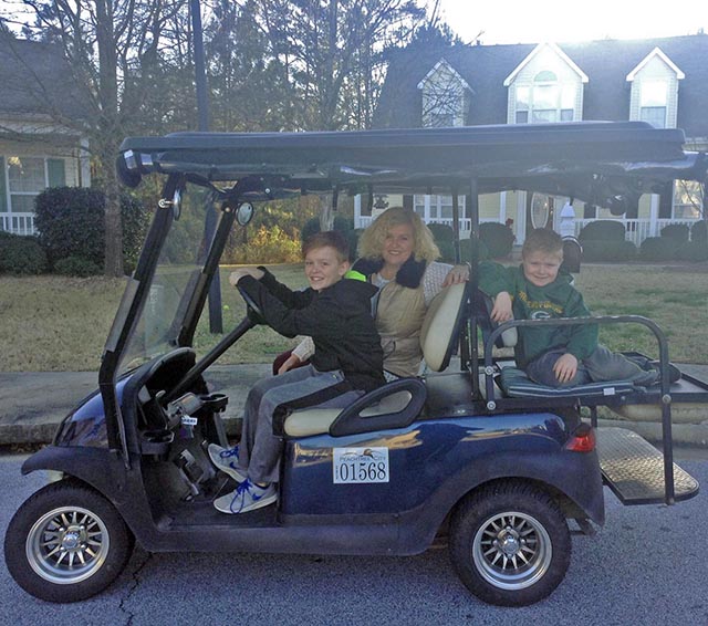 A Peachtree City family enjoys a ride on a golf cart.