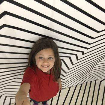 Kid Reporter gets creative in an optical illusion room. 