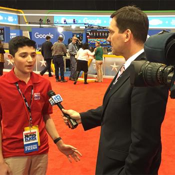 Scholastic News Kid Reporter Gabriel Ferris is interviewed by a TV reporter at a debate in New Hampshire.
